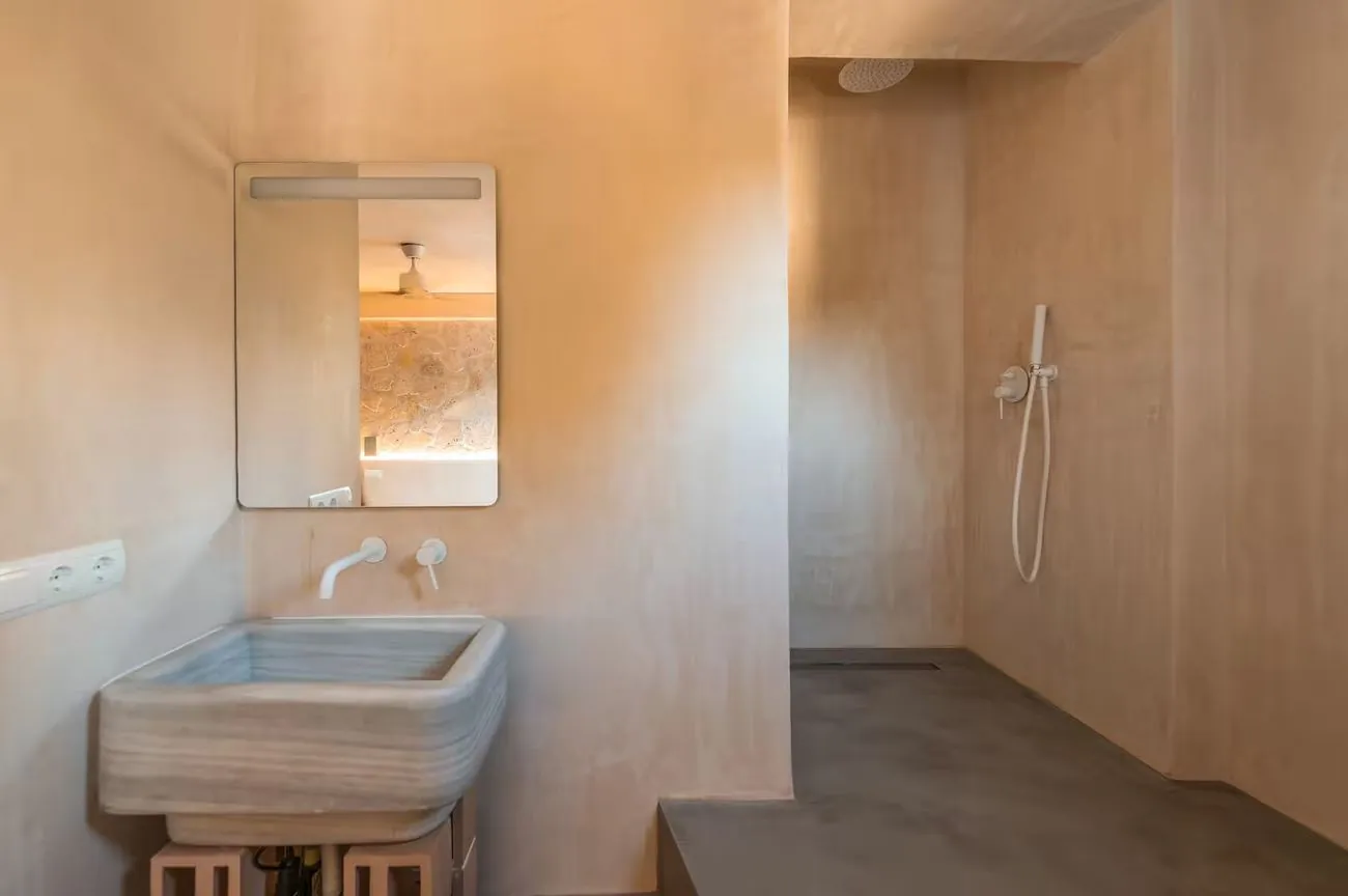 Baño con suelo, encimera y ducha revestidos en Estukum, sin juntas entre superficies
