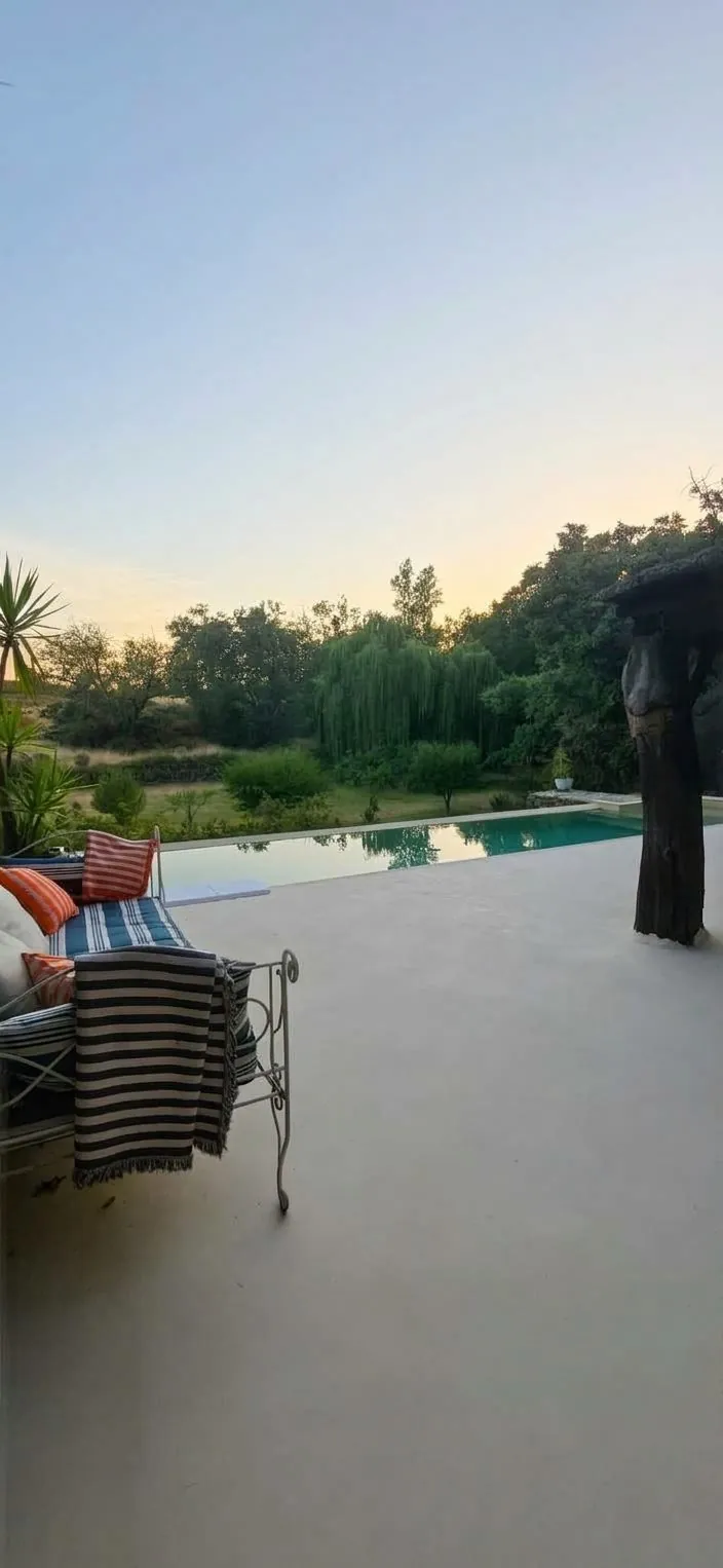 Terraza junto a piscina al atardecer con suelo en Estukum