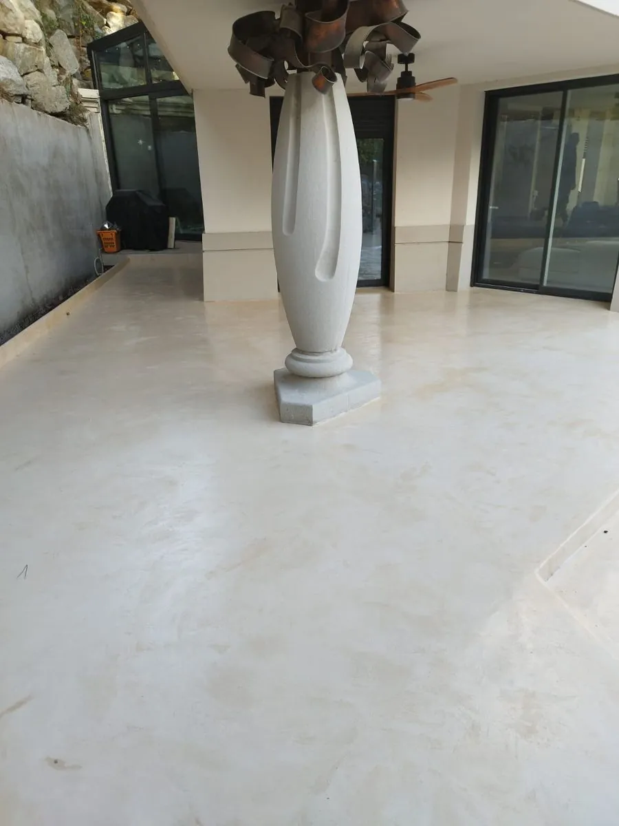 Espacio diáfano con suelo continuo en Estukum claro y escultura blanca